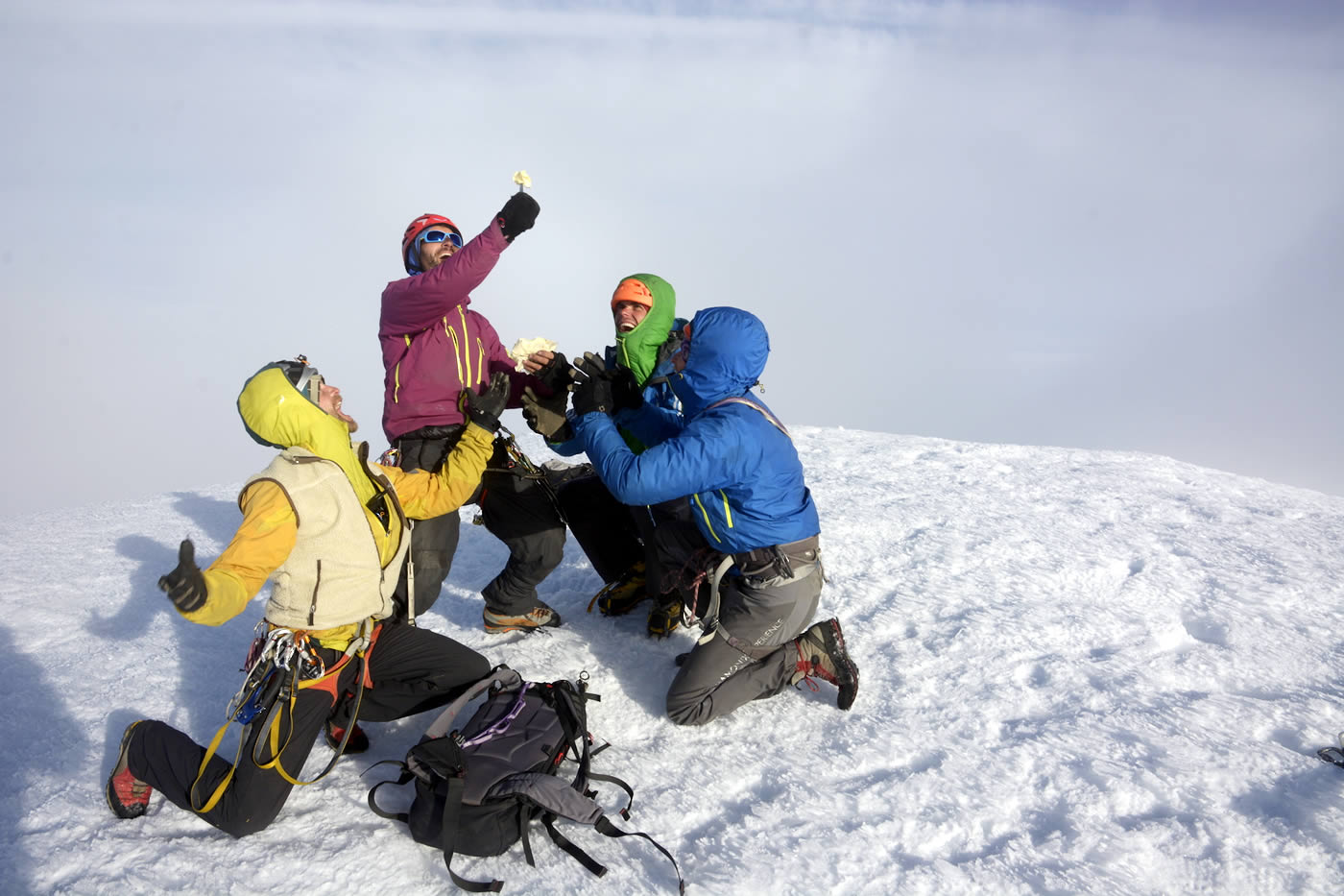 The team kneels on the summit in awe before a piece of Swiss cheese. One of the expedition's sponsors was a Swiss cheese company that provided 25 kilograms of its finest product. Left to right are Antoine Moineville, Fabio Lupo, Christian Ledergerber and Jerome Sullivan. [Photo] Silvan Schuepbach