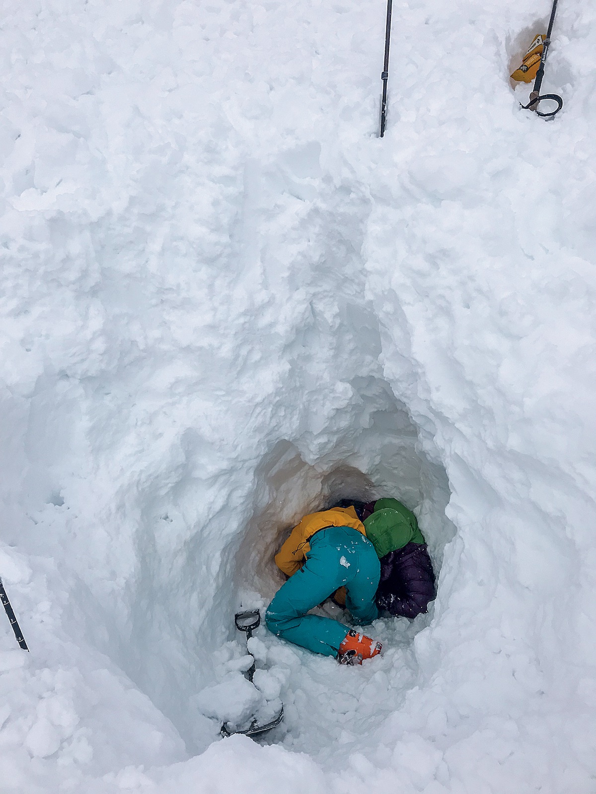 Deep in the consolidated avalanche debris, Maia Schumacher excavates snow around Michelle Kadatz. [Photo] Tim Banfield