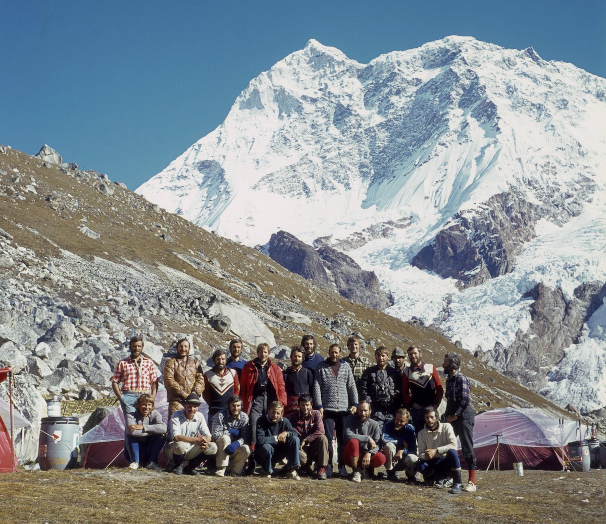 Members of the 1975 Makalu expedition, led by Ales Kunaver, at Base Camp. Zaplotnik is in the front row, first from left (crouching). Kunaver is in the second row, eighth from left. That same year, Chris Bonington was leading a British team on the Southwest Face of Everest. Though miles away, their voices sometimes came through to the Yugoslavians' radio.  [Photo] Courtesy National Museum of Contemporary History, Slovenia
