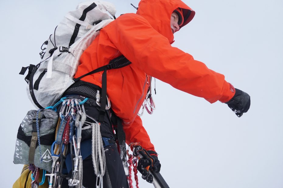 The Alpha-SV works well for alpine climbing; the long hem stays tucked under a harness, chest pockets are easy to access, and the long sleeves, ample hood, and high chin provide excellent coverage from the elements. In this photo Drew Thayer (the author) is wearing the jacket on the first ascent of Spearhead Peak (7,140'), Neacola Range, Alaska. [Photo Craig Muderlak]