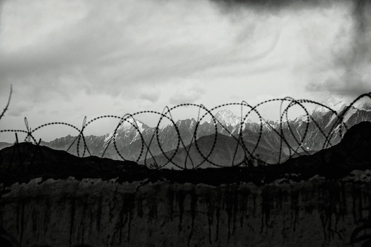 Barbed wire and mountains in Afghanistan: Koh-e-Omah (5766m), left, and Koh-e-Hawar (6266m). [Photo] Matt Traver