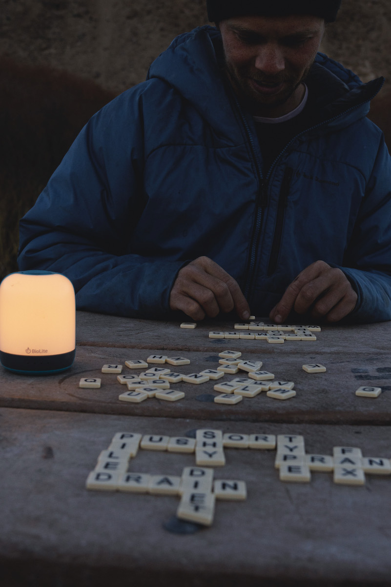 The BioLite AlpenGlow Lantern's candlelight setting illuminates a game of Bananagrams during an autumn night in Indian Creek, Utah, Bears Ears National Monument (Hopi Tribe, Navajo Nation, Ute Mountain Ute Tribe, Pueblo of Zuni, and Ute Indian Tribe land). [Photo] Miya Tsudome