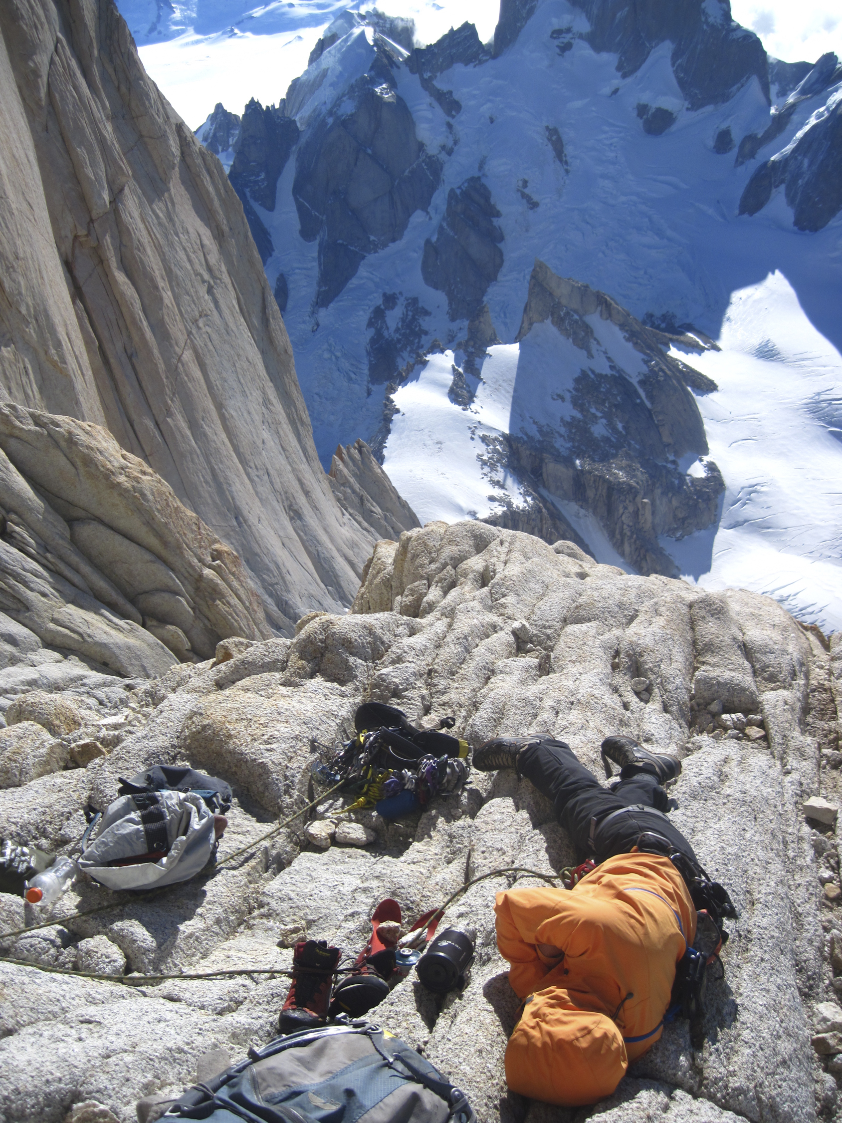 Josh Huckaby catches a little catnap on the three-star ledge high on the North Pillar on Fitz Roy in 2012. He writes, We arrived here too early to actually bivy, because it was still sunny and warm. Plus neither Troutman nor I had a sleeping bag to curl up in together. [Photo] Josh Huckaby Collection