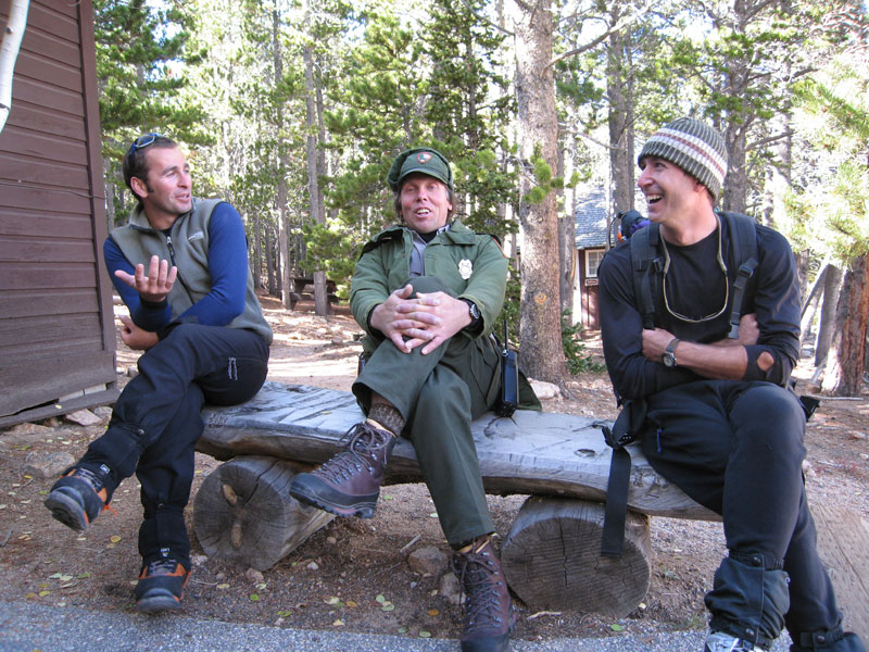 Alex Kostadinov, Jim Detterline and Mark Ronca tell tales at the Longs Peak Ranger Station, September 2005.  The photographer recalls, Jim was stationed at the cabin that day, and Alex, Mark and I stopped by to chat with our friend after a failed attempt on the Smear of Fear (III WI6 M5) on the East Face of Longs Peak. [Photo] Lisa Foster