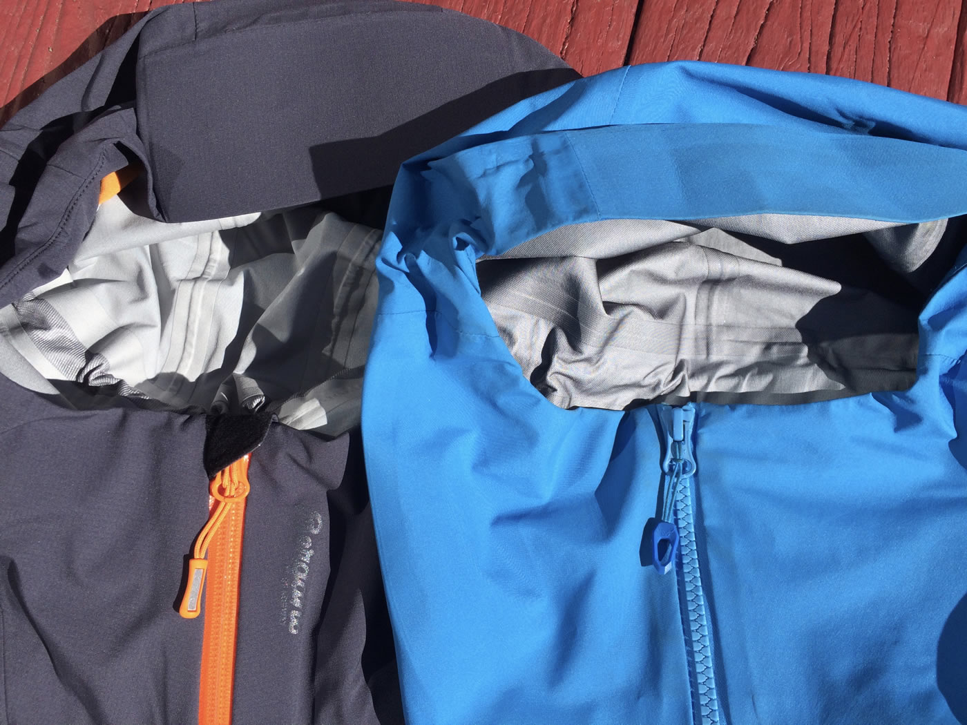 The Bergans Storen Jacket (left), compared with the Dynafit Yotei GTX Jacket (right), has a zipper shed to protect the chin and nose from direct contact with the zipper. [Photo] Mike Lewis