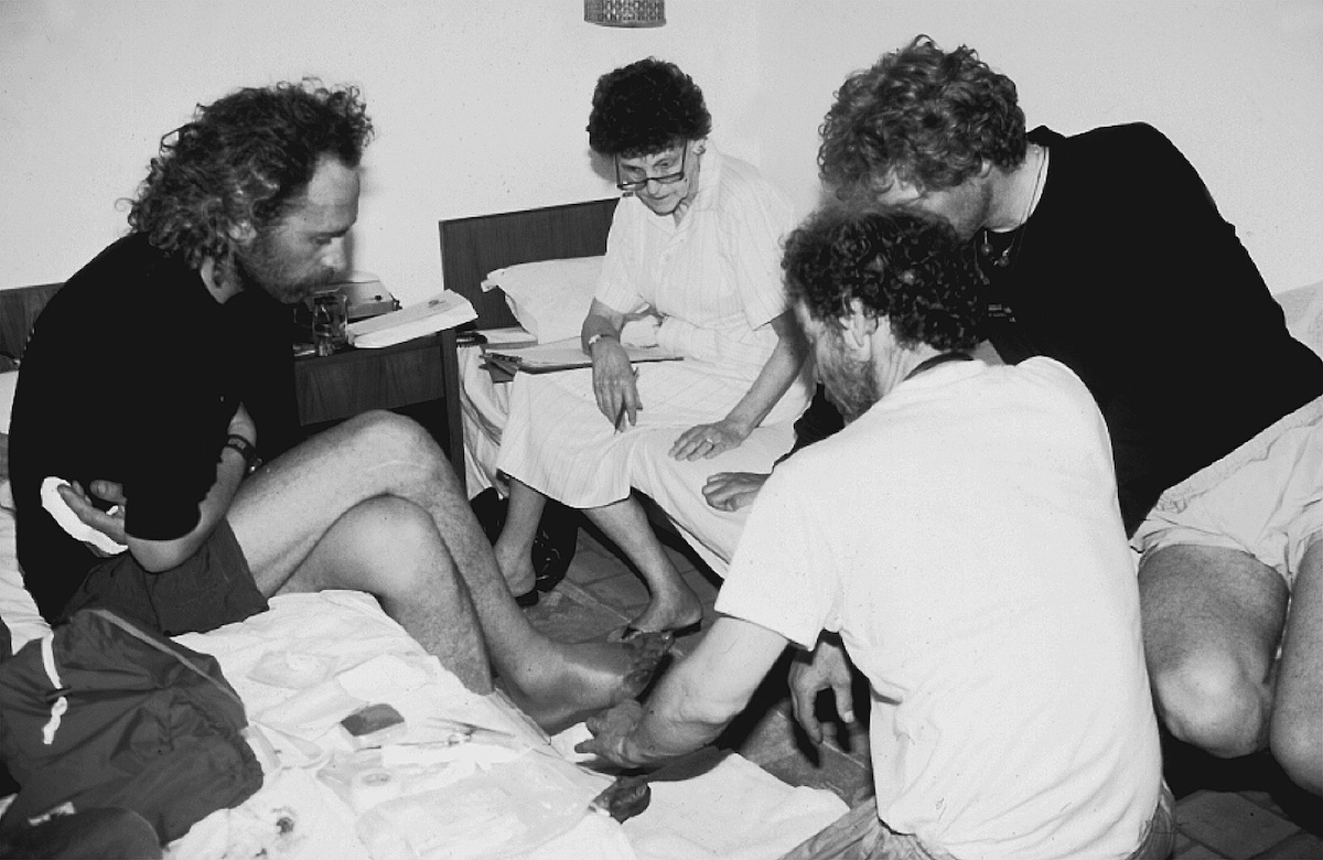 Hawley interviewing a climber with frostbitten toes. [Photo] Courtesy of the Michael and Meg Leonard collection