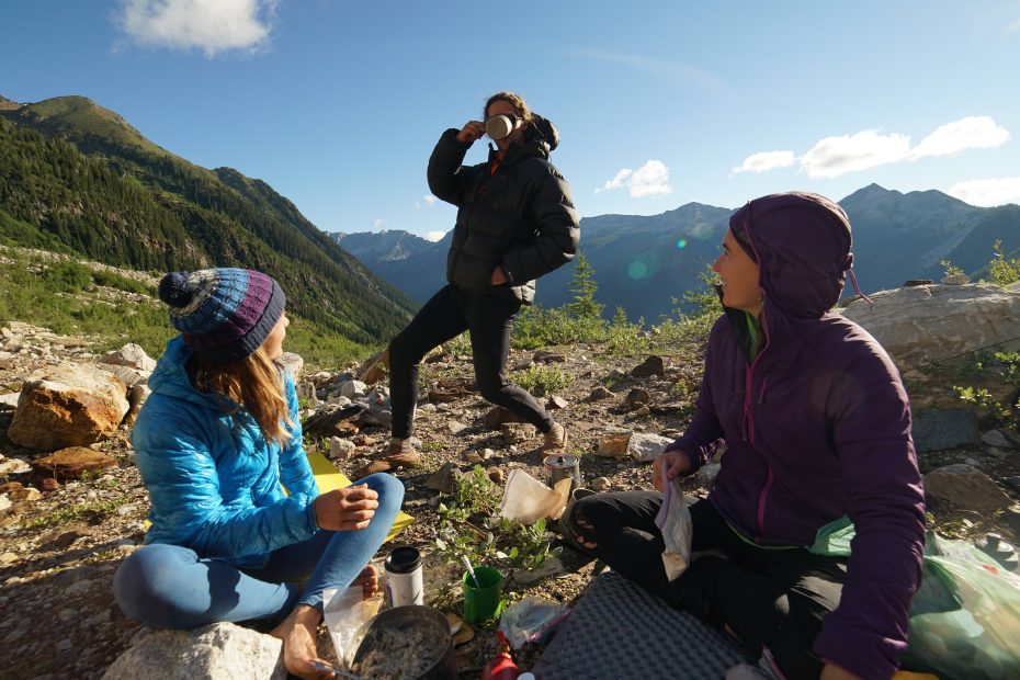 Jenny Abegg and Alix Morris look on as Forest Woodward gets enthusiastic about his morning coffee in basecamp. [Photo] Graham Zimmerman