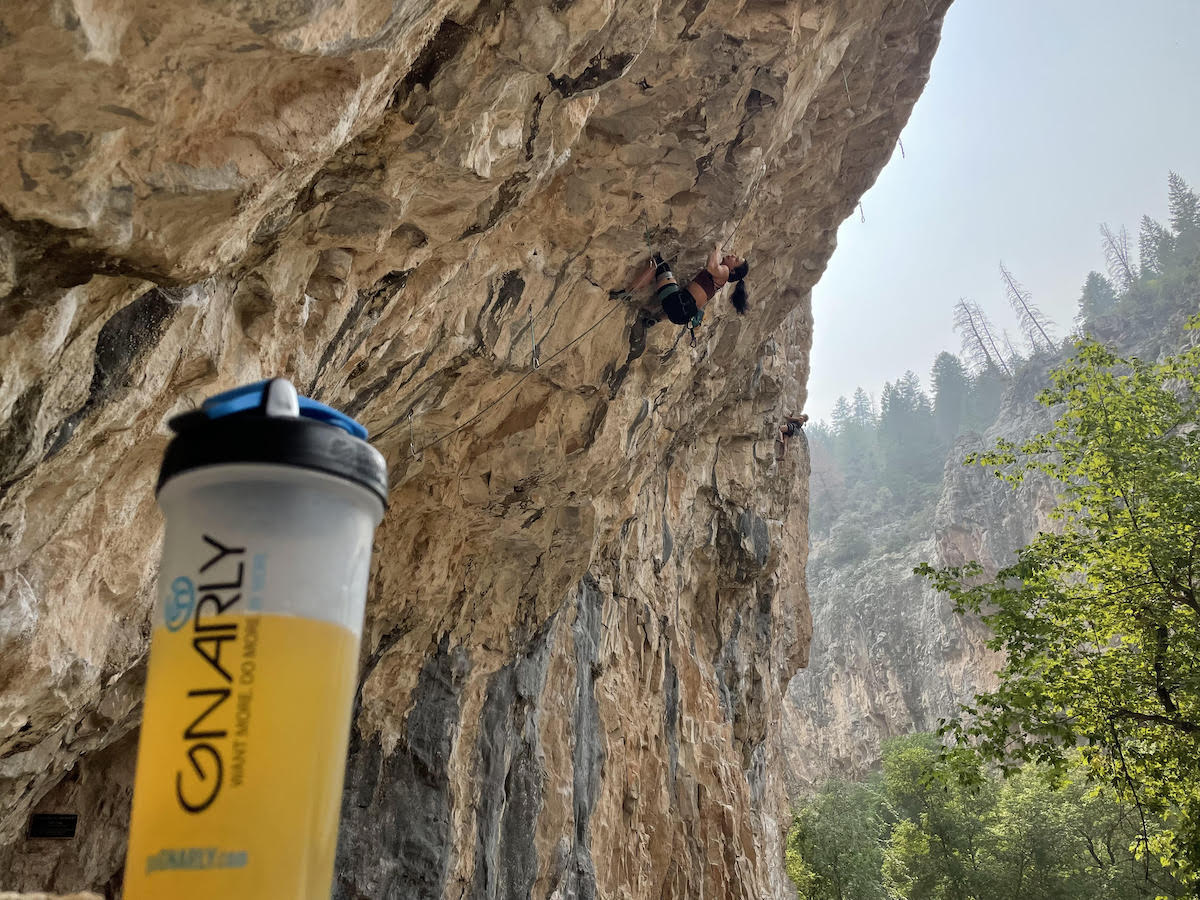 Nina Williams--who is sponsored by Gnarly Nutrition--climbs in the background of the author's BCAA supplement at Rifle Mountain Park, Colorado. [Photo] Derek Franz