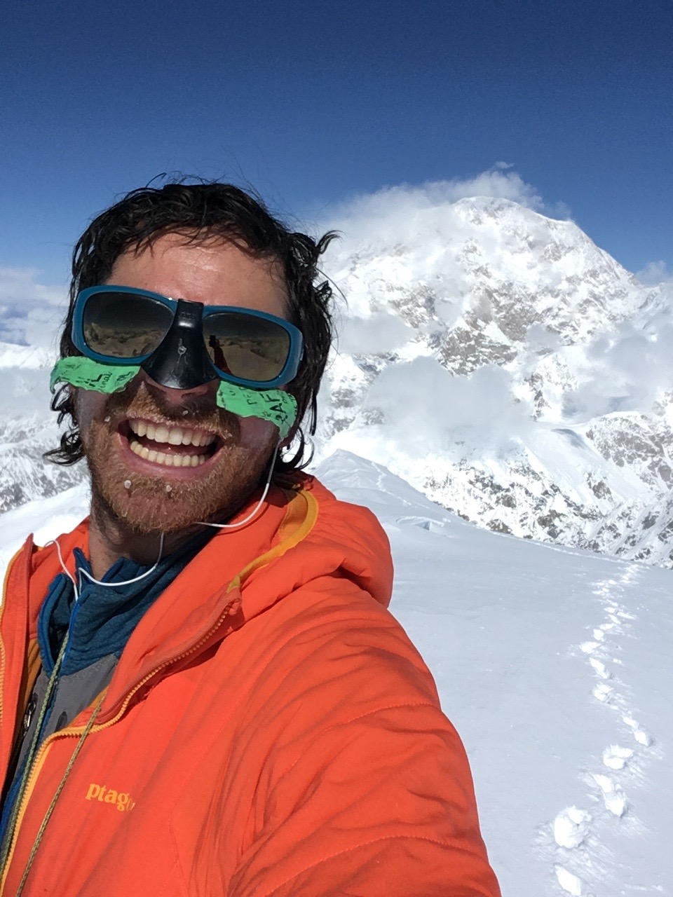 Self-portrait on the summit of Begguya (14,573'). Denali (20,310') is in the background. [Photo] Colin Haley