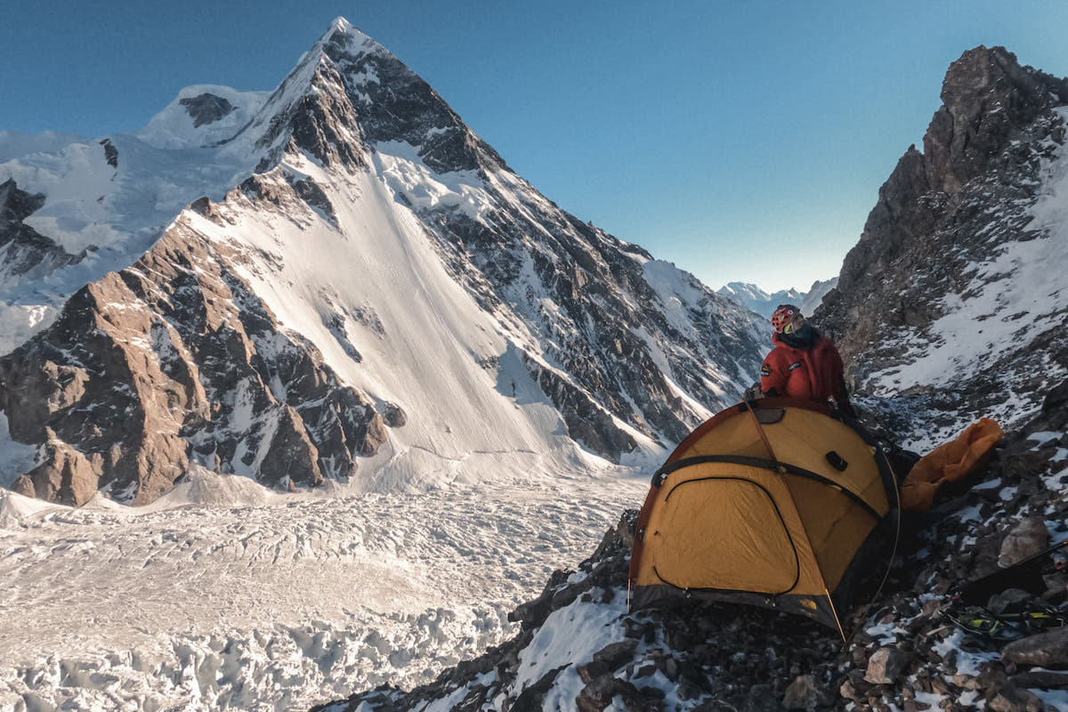 Lunger setting up the tent at the Japanese Camp at 5750 meters. Broad Peak is in the background with the Godwin Austen Glacier below. [Photo] Alex Gavan