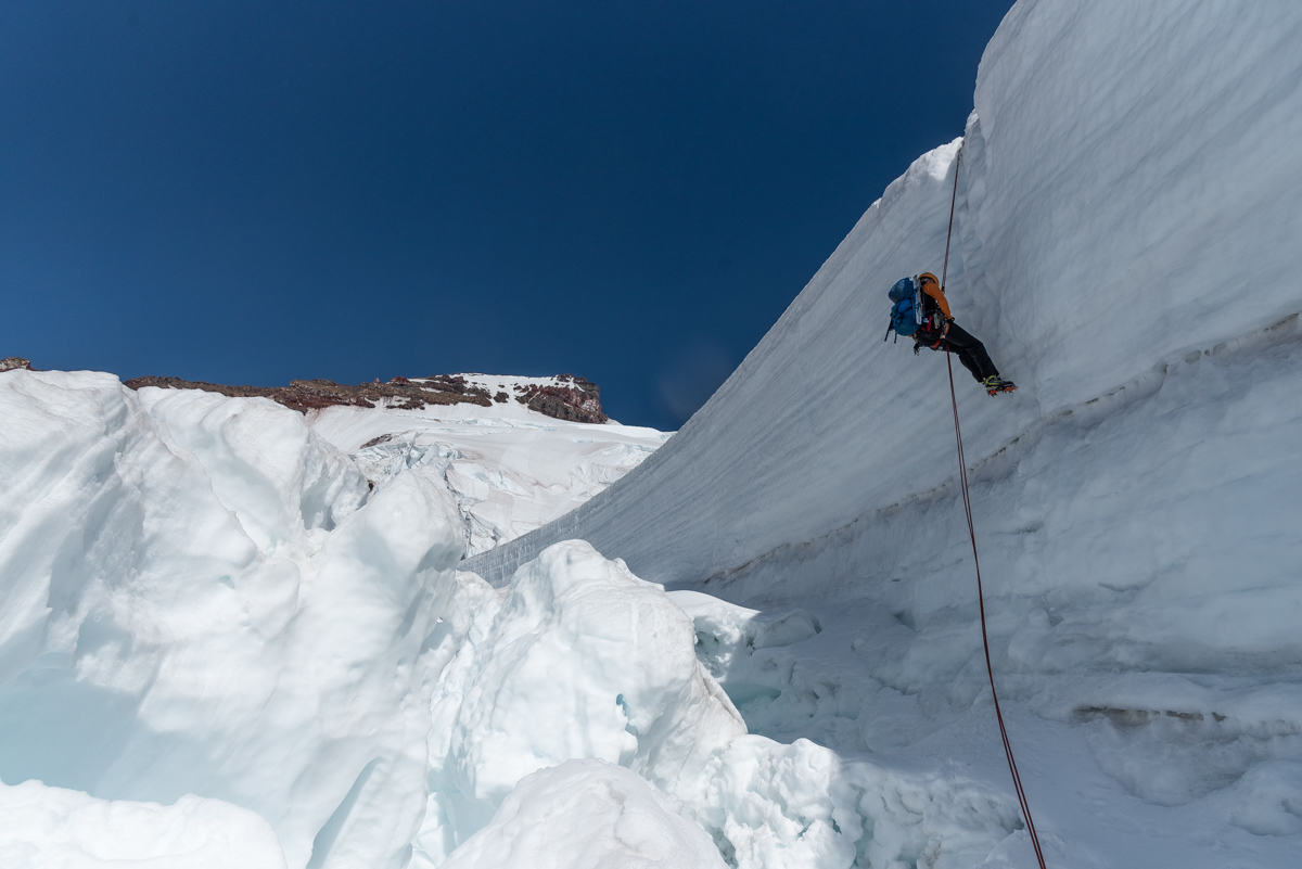 Rappelling over the wide crevasse on the Coleman Glacier while descending from the North Ridge of Koma Kulshan (Mt. Baker). [Photo] Matthew Tangeman