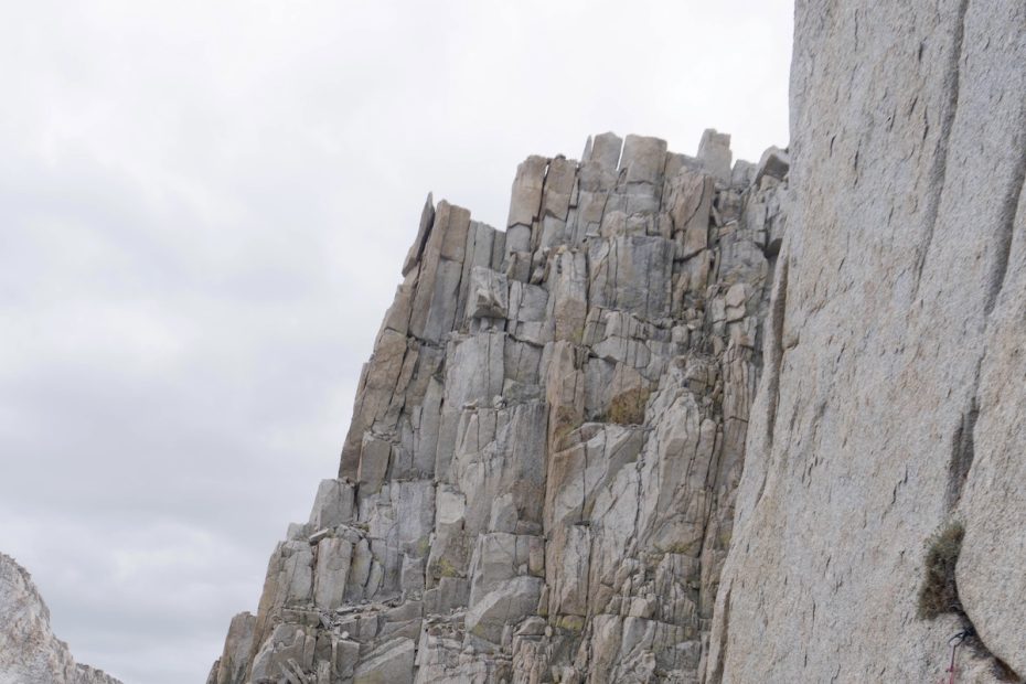 Whitney Clark wears the Patagonia Nano-Air Light Hoody while leading a pitch on the first ascent of High Fashion (5.10, 1,000') on a peak near Wales Lake in the Sierra Nevada Range. The team found a tiny pill container that contained a summit register and identified the mountain as Wales Lake Peak. The register only had two ascents from teams who walked up the backside, Clark said. [Photo] Tad McCrea