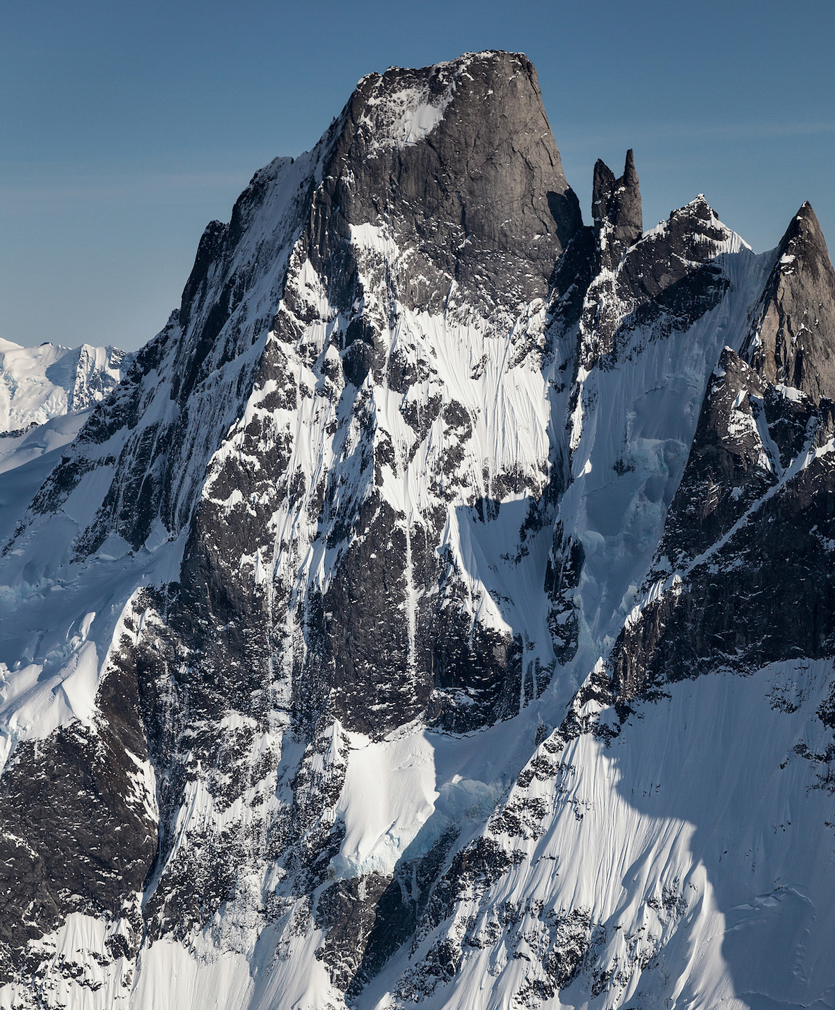 Devils Thumb, North Pillar (left) and northwest face (center). The face has never been climbed in its entirety. As Dieter Klose wrote in the 2003 American Alpine Journal, The wild face, discovered well over two decades ago, ends on a very specific summit. Here are all the makings of both post-modern and futuristic alpinism, yet it simply has not, does not, and seems not to be do-able. [Photo] John Scurlock