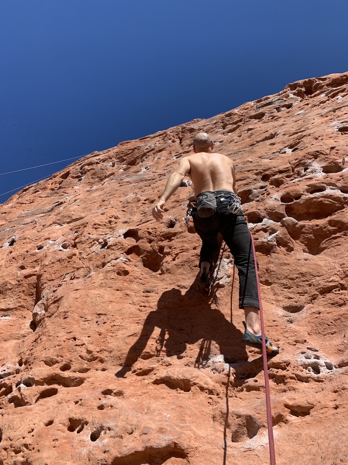 The author climbs confidently at the Chuckawalla Wall near St. George, Utah, knowing his partner below is using the Trango Vergo. [Photo] Catherine Houston
