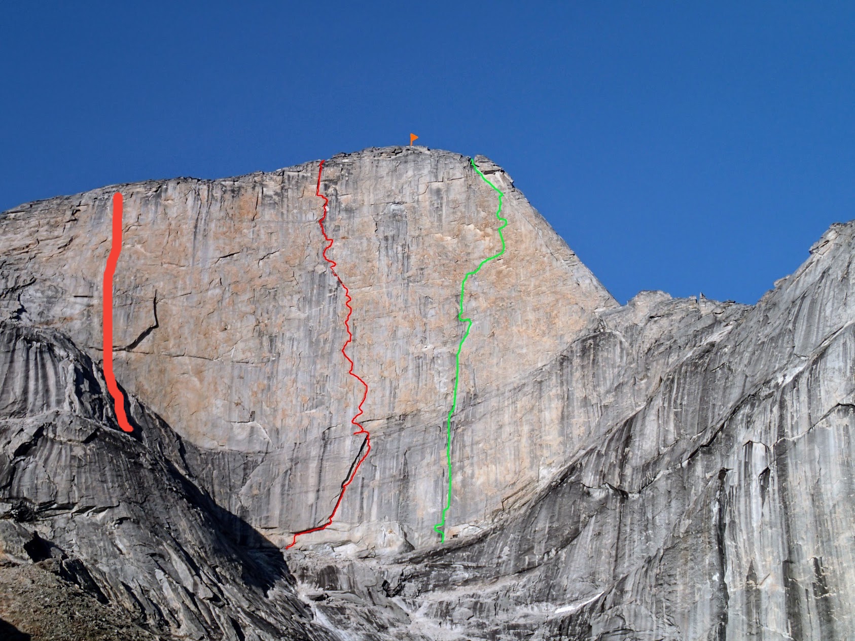 The west face of Xanadu: Golden Petals (V 5.13+ or 5.12 A0, 14 pitches) is marked in green on the right, Une pas mes (VI 5.10b A4/A4+, 11 pitches) is marked by the thin red line at center; the third route, Arctic Knight (V 5.11+, 7 pitches, ca. 1,600'), is marked in a thicker red line to the left of the previous two. [Photo] Engberg, Bain, Boning and Braasch collection
